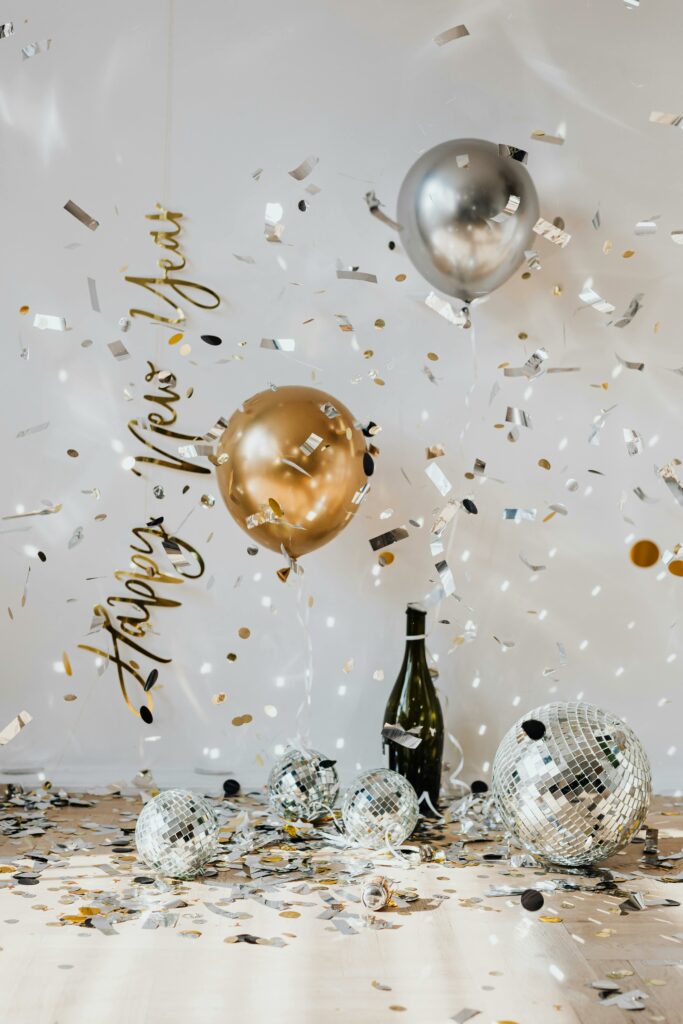 A festive New Year's Eve celebration with balloons, confetti, and sparkling lights.