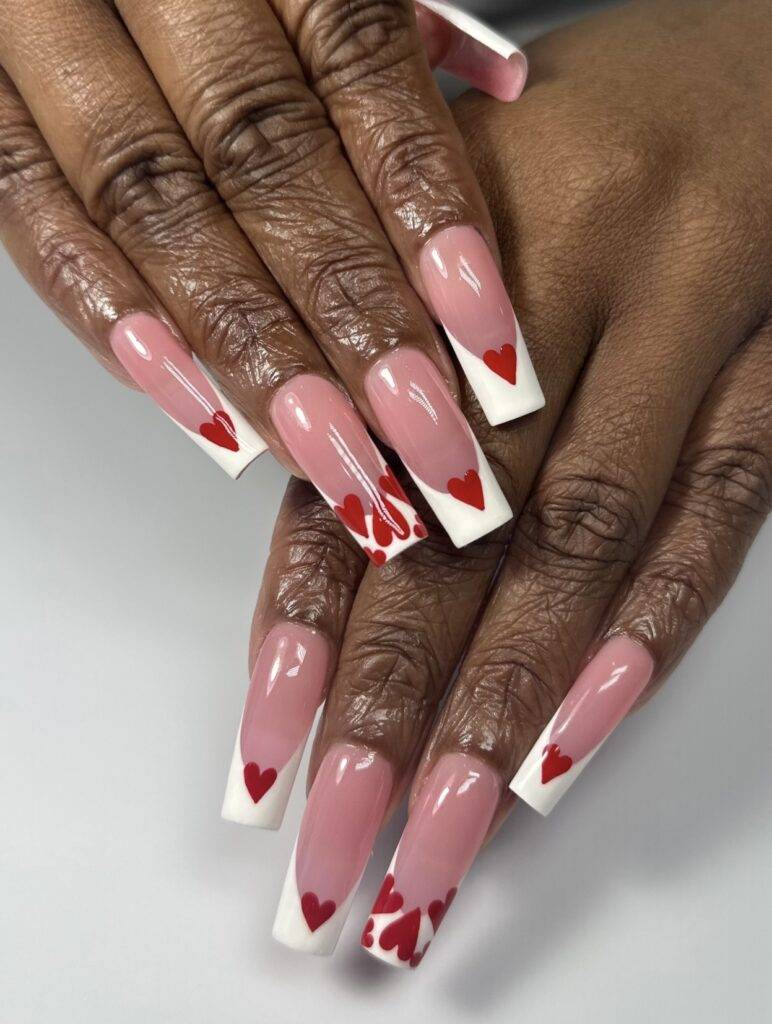 Elegant Valentine’s Day nails with white French tips and heart designs, perfect for a timeless and romantic look in Las Vegas.