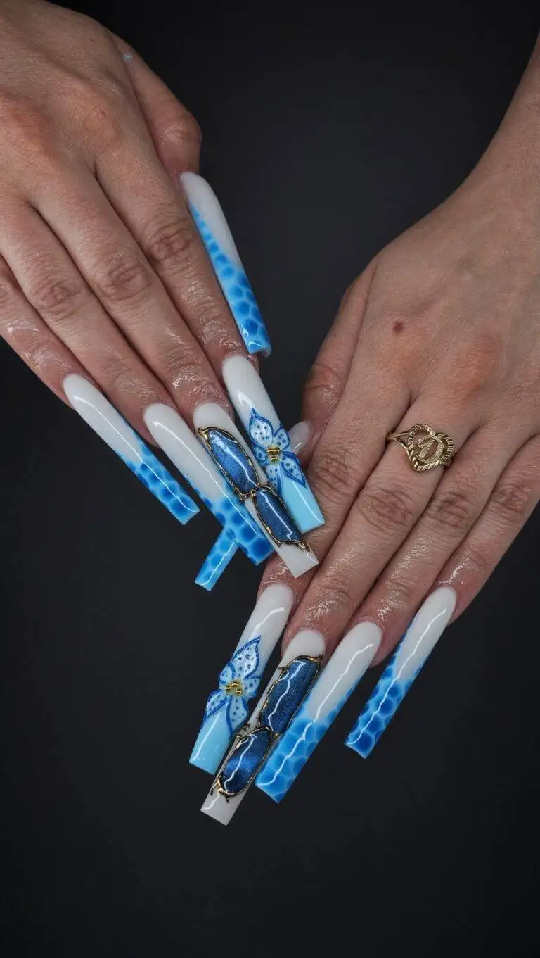 Long coffin nails with white and blue ombré and butterfly decals gold accents on two nails hand wearing a gold ring against a dark background Nab nail bar | nails lashes and beauty in las vegas