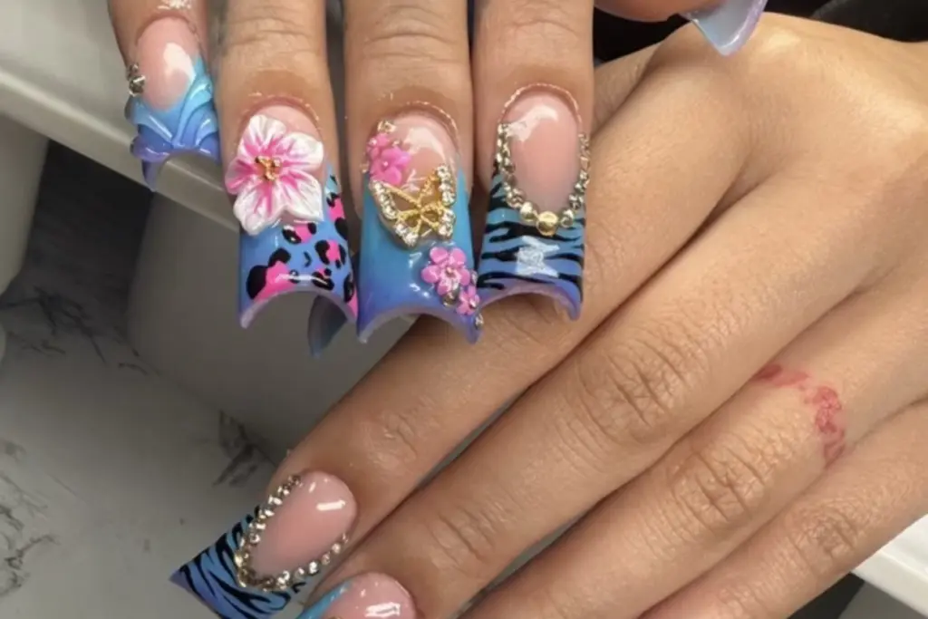 Duck Nails with Zebra Print and 3d Flowers Nab Nail Bar | Nails Lashes and Beauty in Las Vegas Duck nails in blue and turquoise with zebra print 3d flowers and rhinestone accents on dramatically flared tips nab nail bar | nails lashes and beauty in las vegas