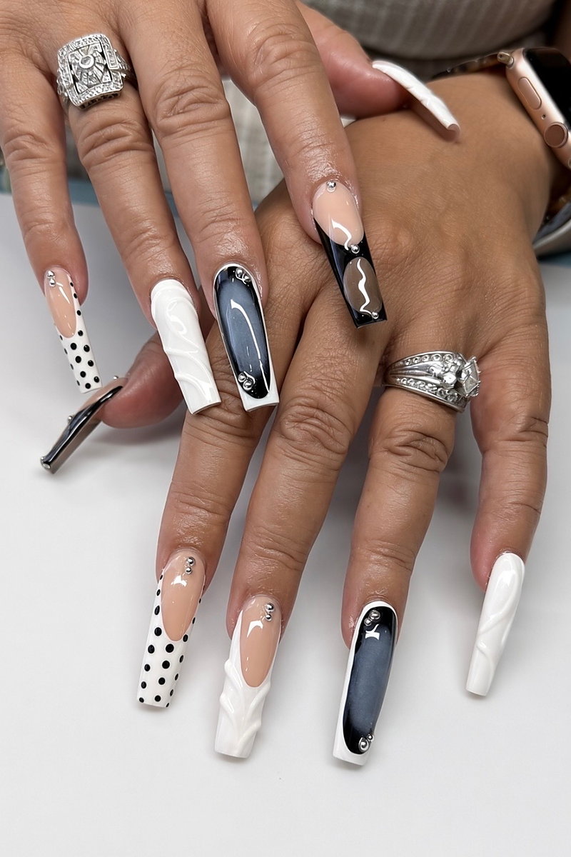 Long coffin Gel X nails with black and white designs, polka dots and rhinestones, done at NAB Nail Bar in Las Vegas