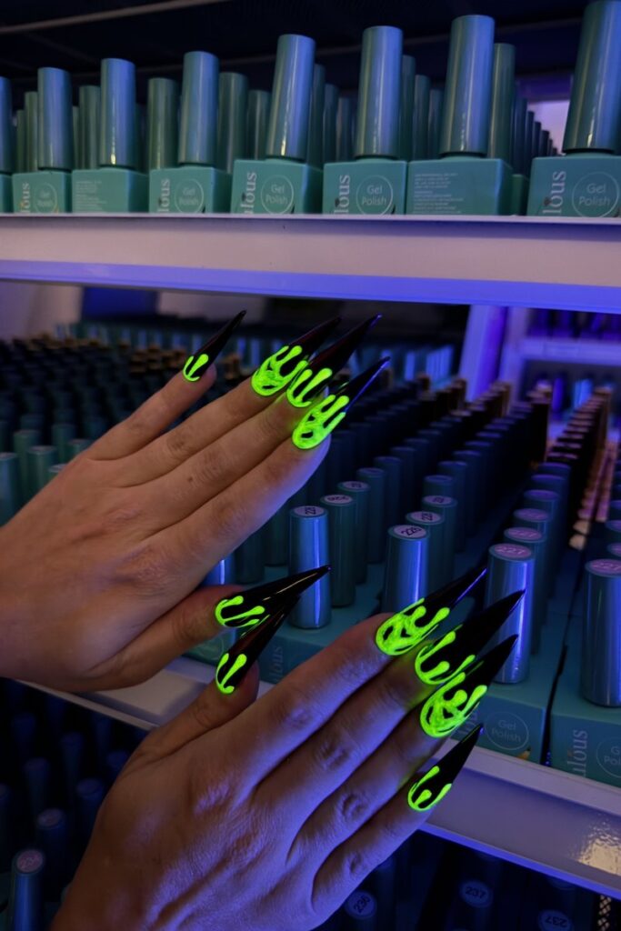 Glow in the Dark Halloween Nails Las Vegas Nab Nail Bar | Nails Lashes and Beauty in Las Vegas Glow in the dark halloween nails neon green drip design on long black stiletto nails under blacklight at nab nail bar in las vegas nab nail bar | nails lashes and beauty in las vegas