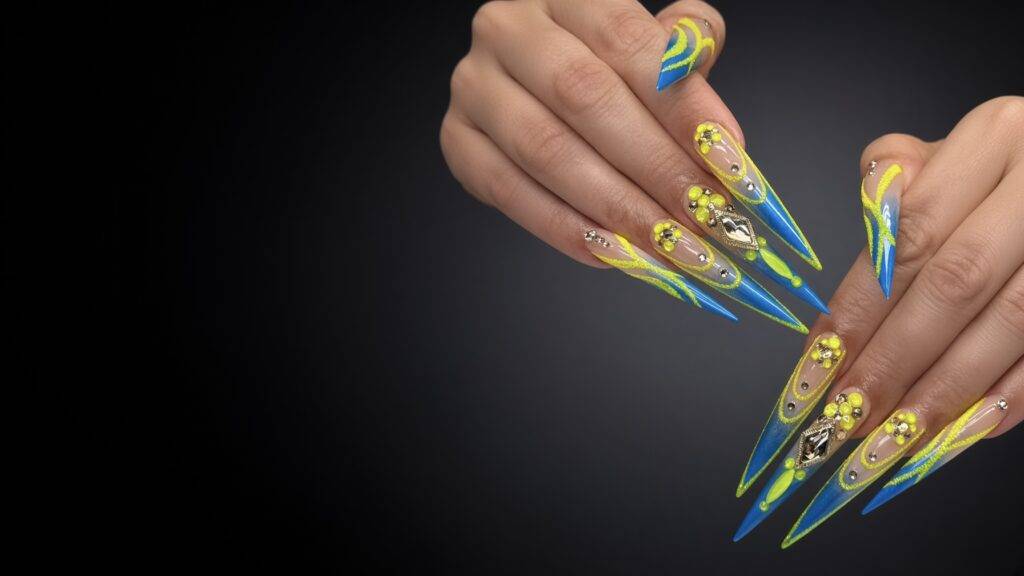 Long stiletto Gel X nails in neon yellow and blue with rhinestones and 3D flowers at NAB Nail Bar in Las Vegas