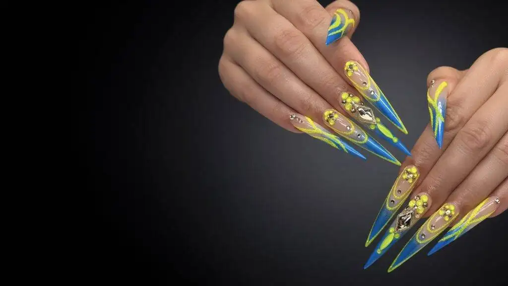 Long stiletto Gel X nails in neon yellow and blue with rhinestones and 3D flowers at NAB Nail Bar in Las Vegas