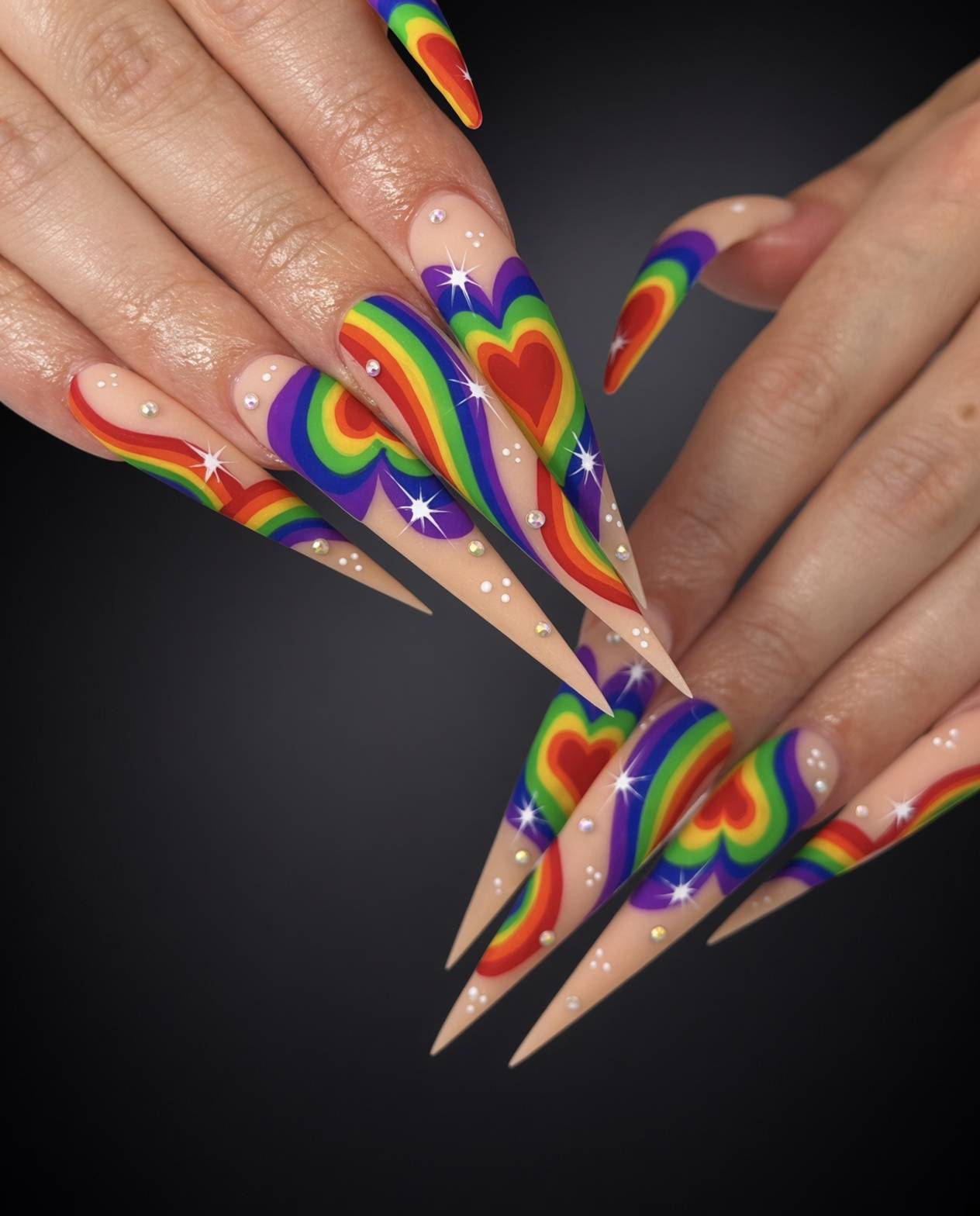 Long stiletto nails with rainbow heart nail art rhinestones and starburst tips done at nab nail bar in las vegas nab nail bar