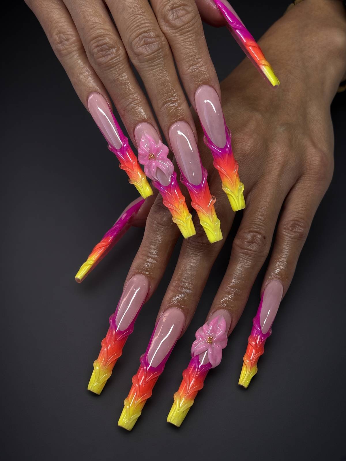 Long coffin nails with a pink to yellow ombre and a 3d pink flower accent custom nail art at nab nail bar in las vegas nab nail bar