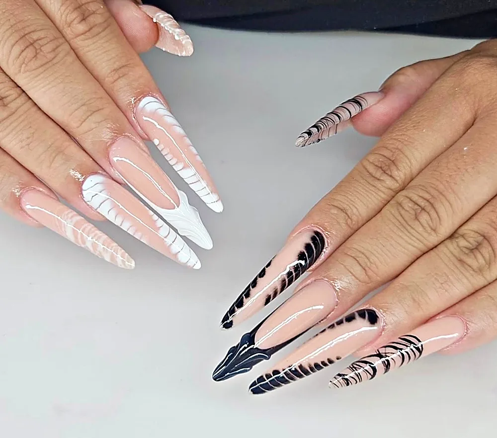 Extra long stiletto Gel X nails in nude with black and white marble and 3D sculpted tips at NAB Nail Bar in Las Vegas