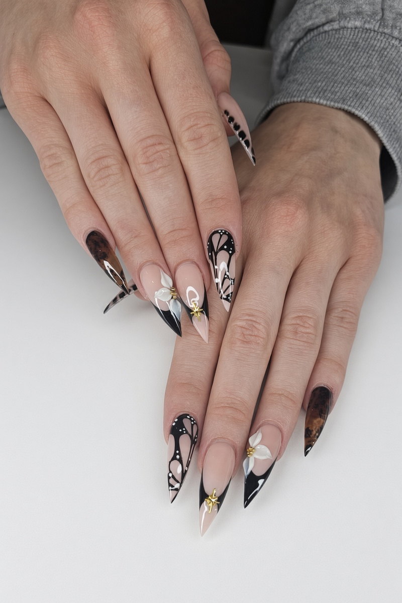 Black and tortoiseshell stiletto nails with hand painted white butterfly art and small gold accents nab nail bar