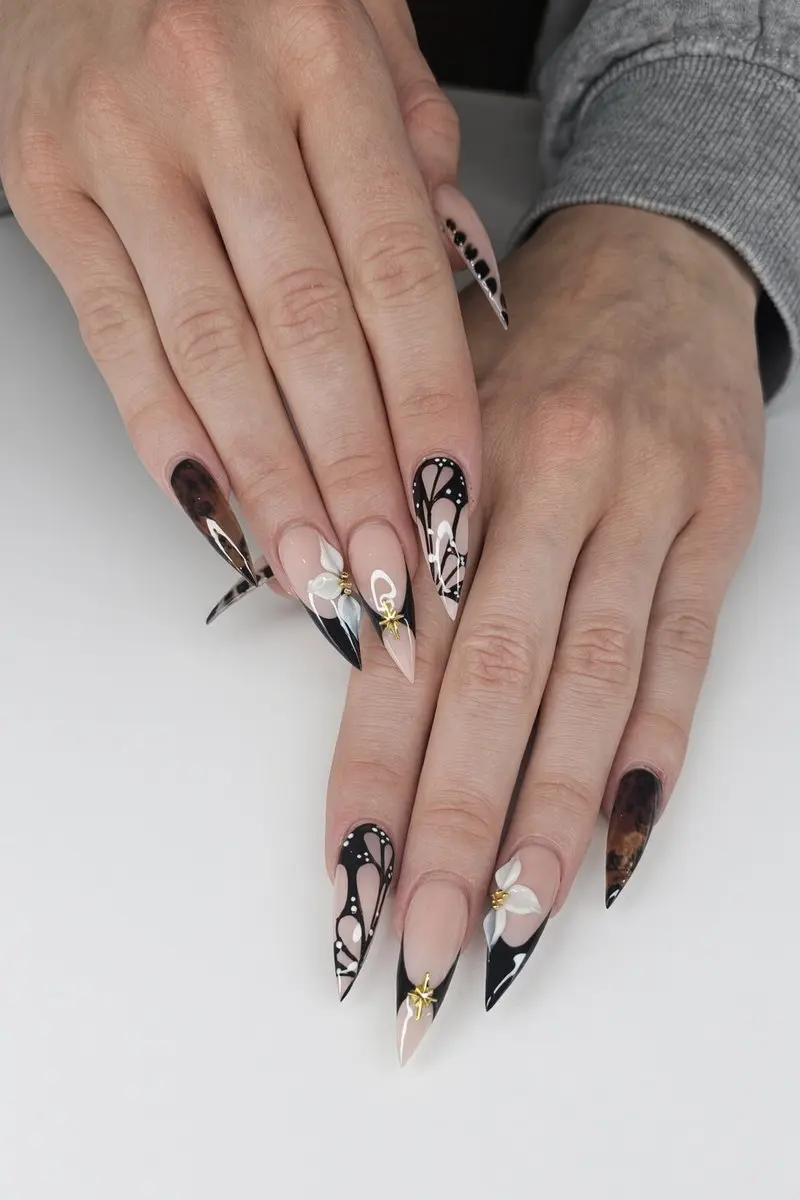 Black and tortoiseshell stiletto nails with hand painted white butterfly art and small gold accents nab nail bar