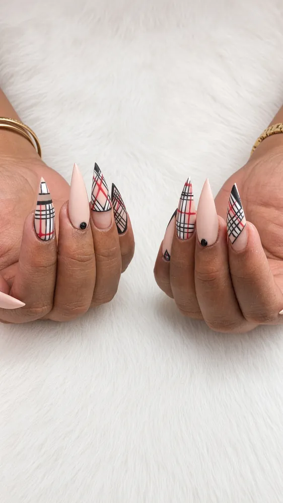 Nude matte stiletto nails with black and red plaid accent nails and a black gem, holiday party set at NAB Nail Bar Las Vegas