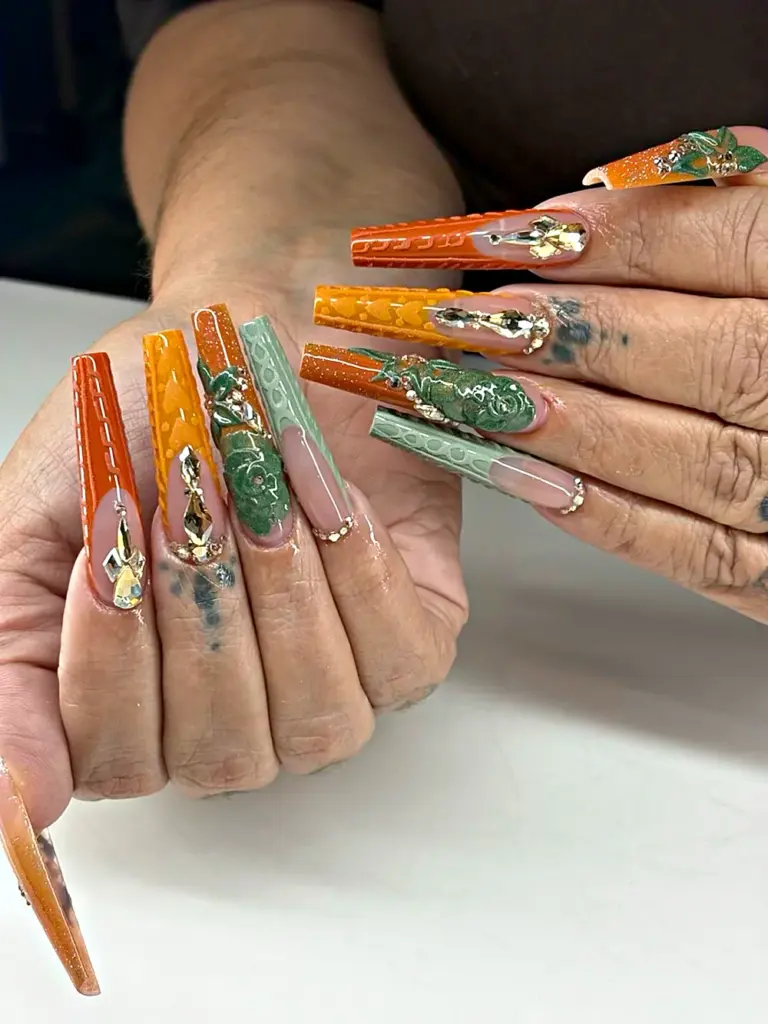 Long coffin Gel X nails in orange, mustard and sage with sweater texture, 3D roses and crystals at NAB Nail Bar in Las Vegas