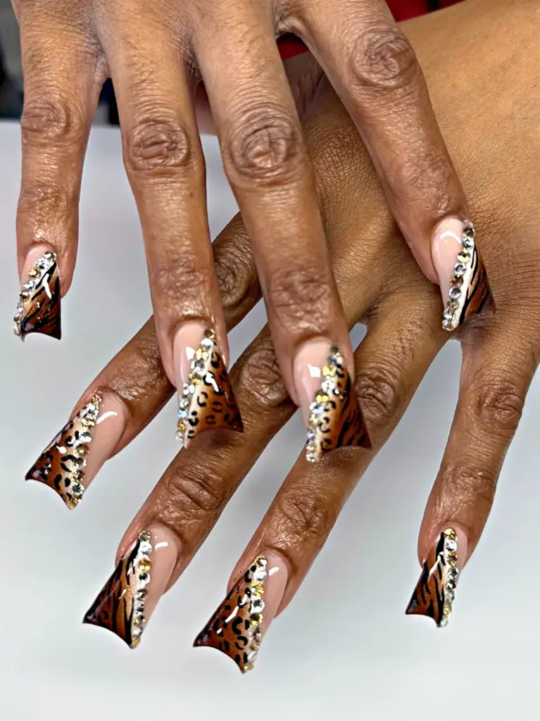 Long slanted gel x duck nails with leopard and tiger print and a crystal line at nab nail bar in las vegas nab nail bar