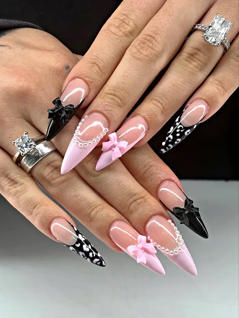 Long stiletto Gel X nails in pink and black with 3D bows, pearls and leopard print at NAB Nail Bar in Las Vegas
