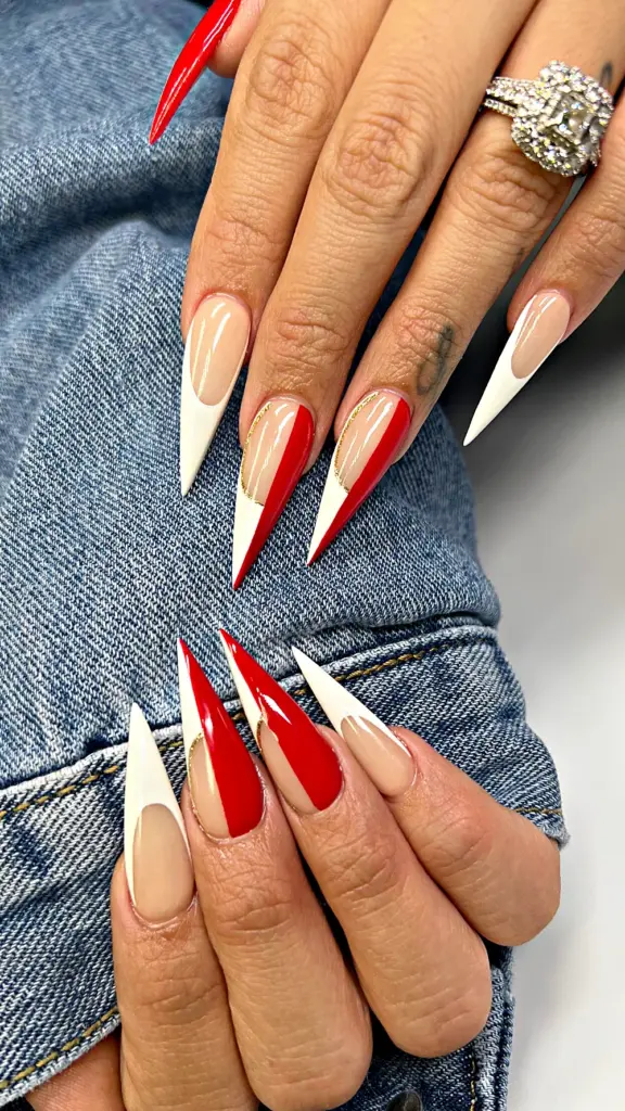 Long stiletto Gel X nails with a red and white split French and a gold line at NAB Nail Bar in Las Vegas