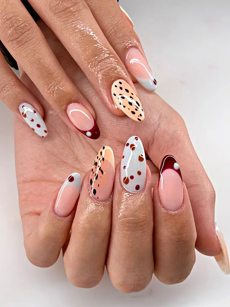 Medium almond Gel X nails with dalmatian dots and a burgundy French tip at NAB Nail Bar in Las Vegas