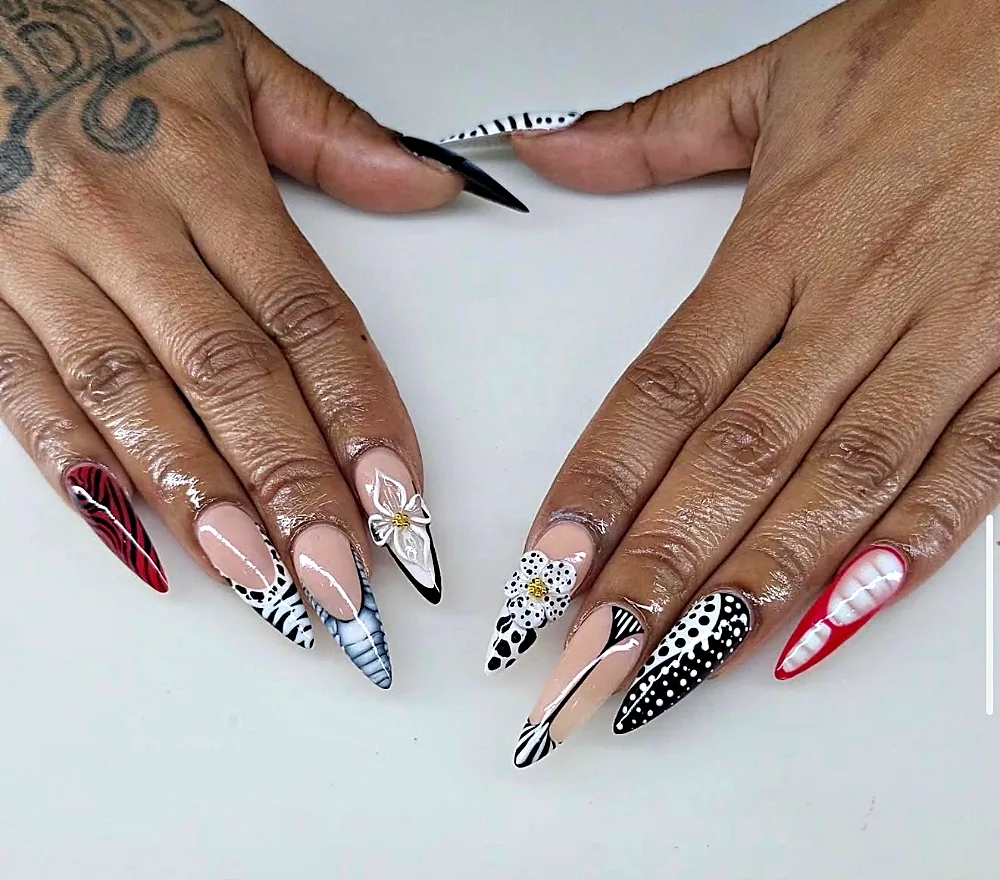 Medium stiletto Gel X nails with black and white animal print, polka dots and 3D flowers at NAB Nail Bar in Las Vegas