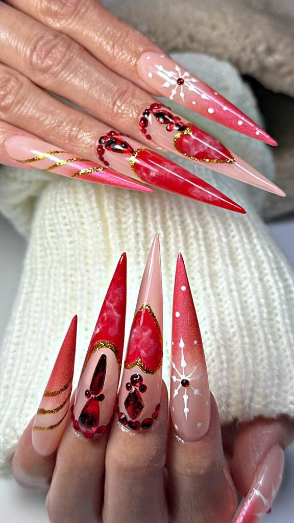 Red and gold Christmas stiletto nails with marble hearts, snowflakes and red crystals at NAB Nail Bar, Las Vegas