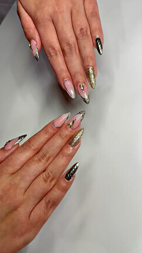 Short almond Gel X nails with gold chrome, gold glitter and gold outlines at NAB Nail Bar in Las Vegas