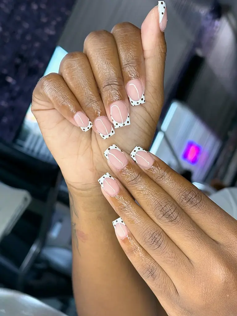 Short square Gel X nails with a white French tip and black polka dots at NAB Nail Bar in Las Vegas