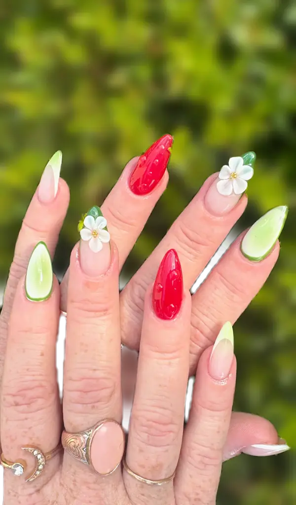 Short stiletto Gel X nails with jelly strawberry red, lime green French and 3D white flowers at NAB Nail Bar in Las Vegas
