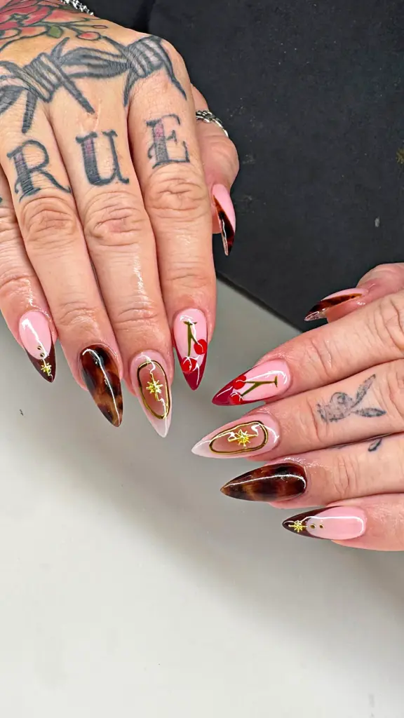 Short stiletto Gel X nails with tortoiseshell, red French cherries and gold stars at NAB Nail Bar in Las Vegas